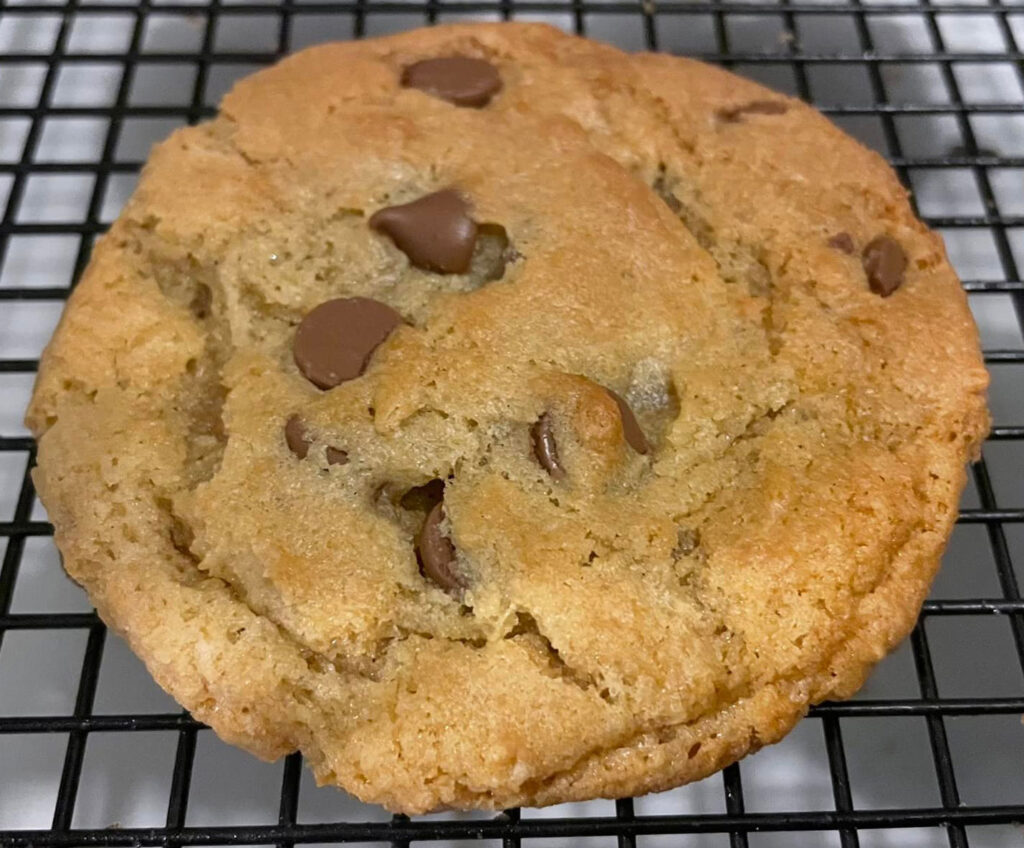 closeup of chocolate chip cookie on wire baking rack