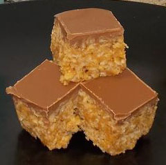 photo of a pyramid stack of three scotcharoos with a krispy rice base and a top layer of chocolate
