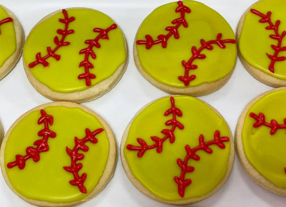 picture of gluten-free round cutout sugar cookies that look like baseballs, yellow frosting with red threaded accent