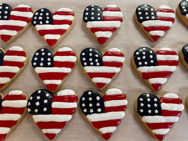 photo of nine heart-shaped gluten-free cutout sugar cookies decorated as USA flags