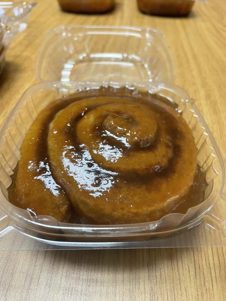 picture of a dairy-free, gluten-free caramel sweet roll in a plastic container